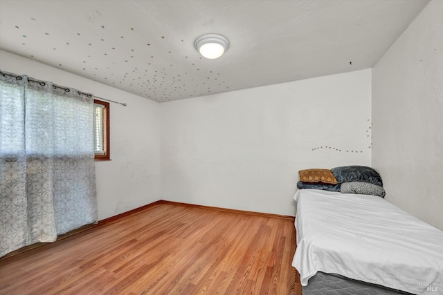 unfurnished bedroom featuring baseboards and wood finished floors