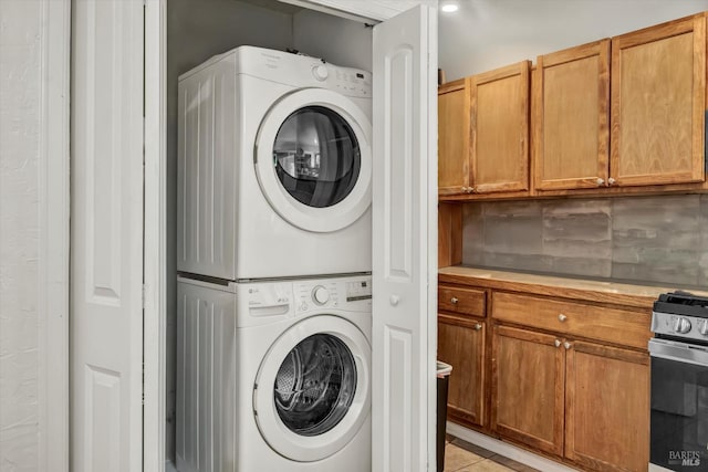 clothes washing area featuring stacked washing maching and dryer and laundry area