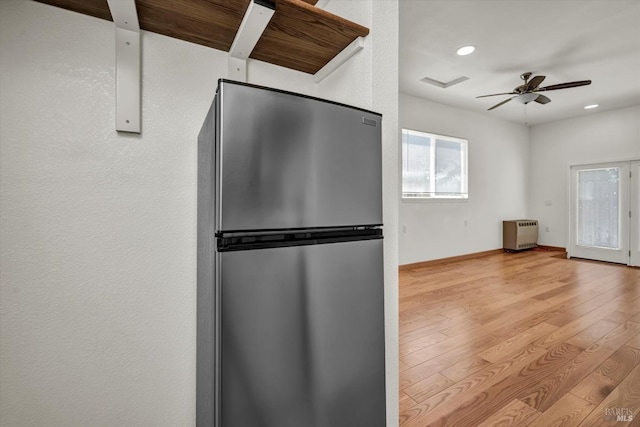 kitchen with a ceiling fan, freestanding refrigerator, light wood-style floors, heating unit, and recessed lighting