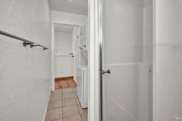 bathroom with tile patterned flooring and stacked washer and clothes dryer