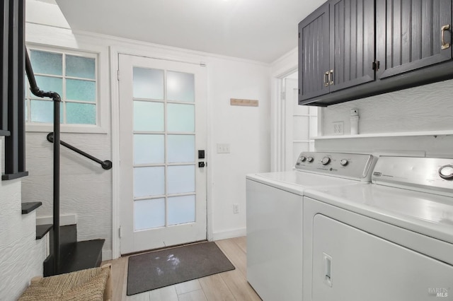 clothes washing area featuring cabinet space, light wood-style floors, ornamental molding, baseboards, and washing machine and dryer
