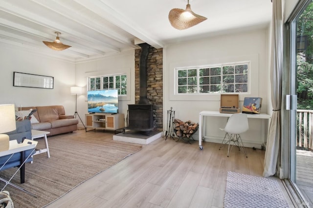 living area with a wood stove, wood finished floors, and beamed ceiling