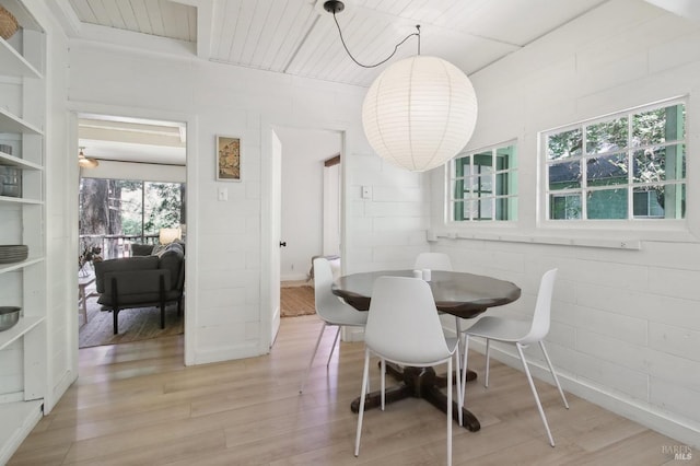 dining room featuring wood finished floors and concrete block wall