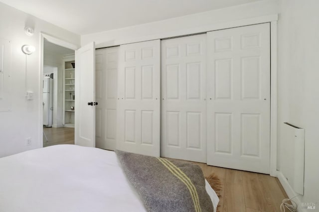 bedroom featuring light wood-style floors and a closet