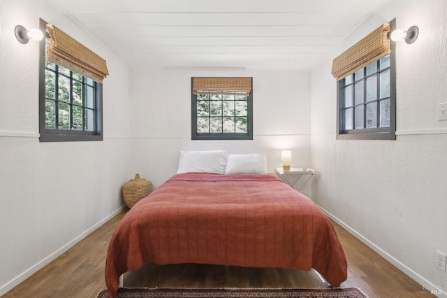 bedroom with baseboards and wood finished floors