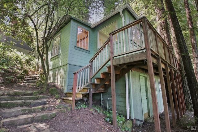 back of property with stairs and a deck