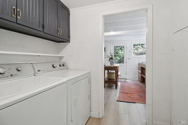laundry room with cabinet space, washing machine and dryer, and light wood-type flooring