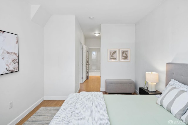 bedroom with baseboards and wood finished floors