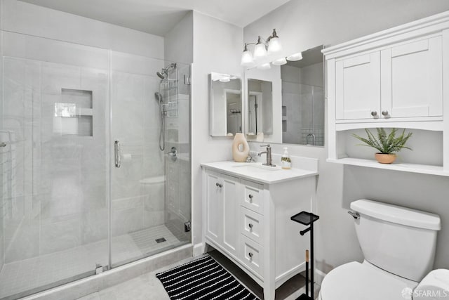 bathroom with toilet, a shower stall, and vanity