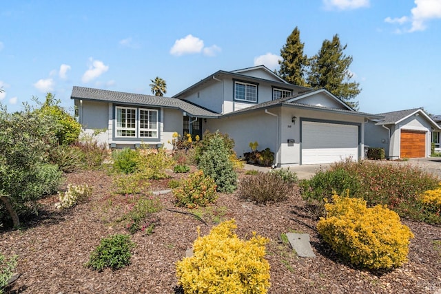view of front of house with an attached garage, concrete driveway, and stucco siding