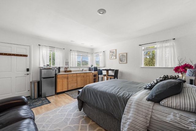 22855 Chianti Rd, Geyserville, CA 95441 - bedroom with freestanding refrigerator, light wood finished floors, and a sink