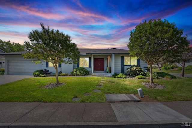 ranch-style house with an attached garage, a front yard, and concrete driveway