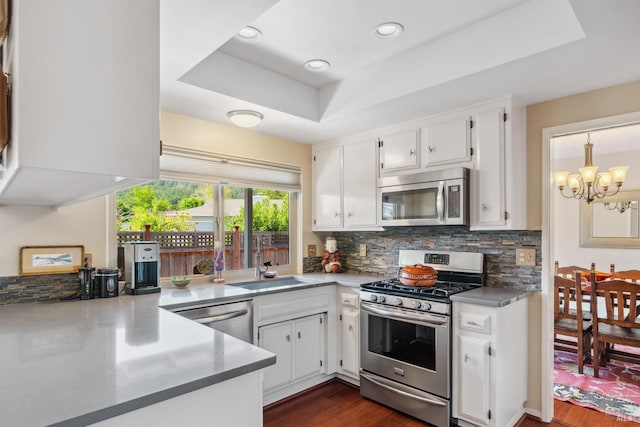 kitchen featuring a sink, appliances with stainless steel finishes, tasteful backsplash, and a chandelier