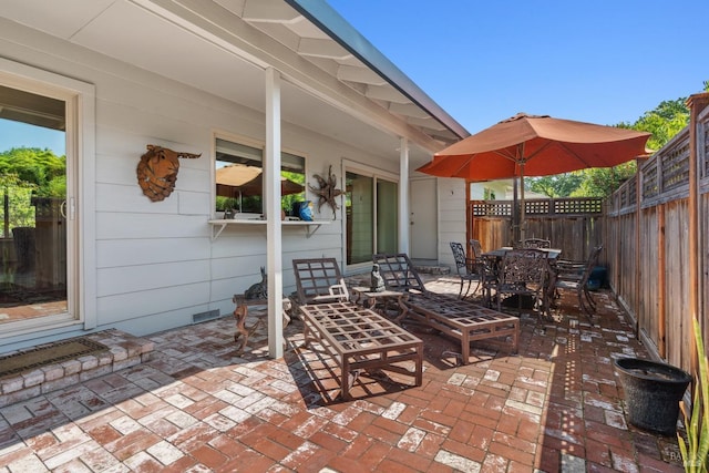 view of patio featuring a fenced backyard, outdoor dining space, and visible vents
