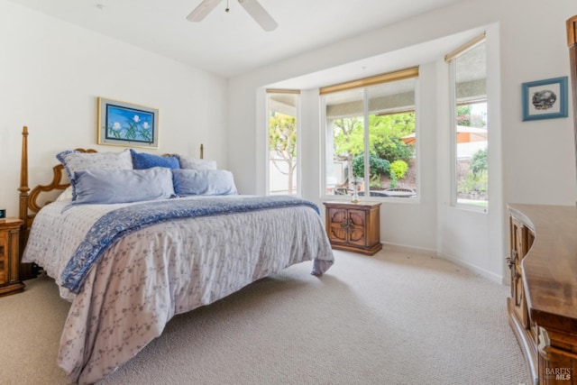 carpeted bedroom featuring baseboards and ceiling fan