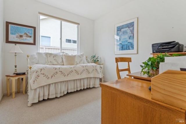 bedroom featuring light carpet and baseboards