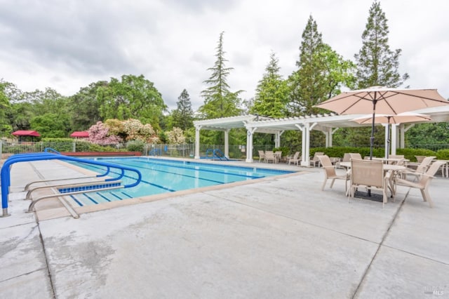 community pool featuring fence, a pergola, and a patio area