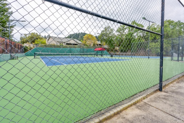 view of tennis court with fence