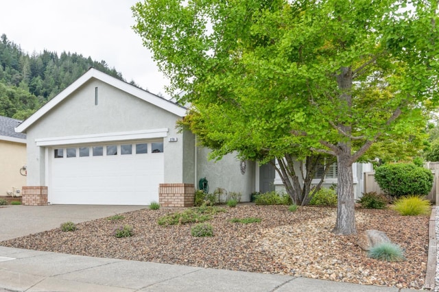 view of front of property with driveway, stucco siding, and a garage