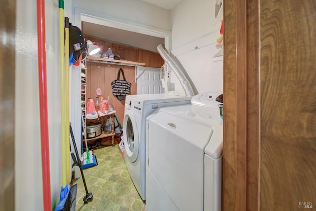 laundry area with laundry area, stone finish flooring, and washing machine and dryer