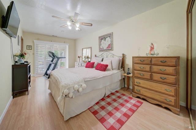 bedroom with light wood-style flooring, baseboards, a ceiling fan, and a closet