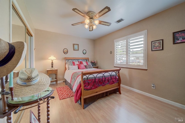 bedroom featuring a closet, baseboards, visible vents, and wood finished floors
