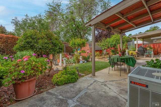 view of patio featuring cooling unit, outdoor dining space, and a fenced backyard