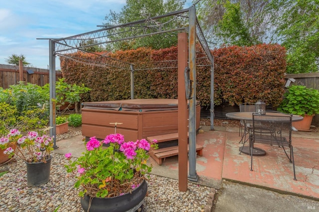 view of patio / terrace featuring outdoor dining area, a hot tub, and a fenced backyard