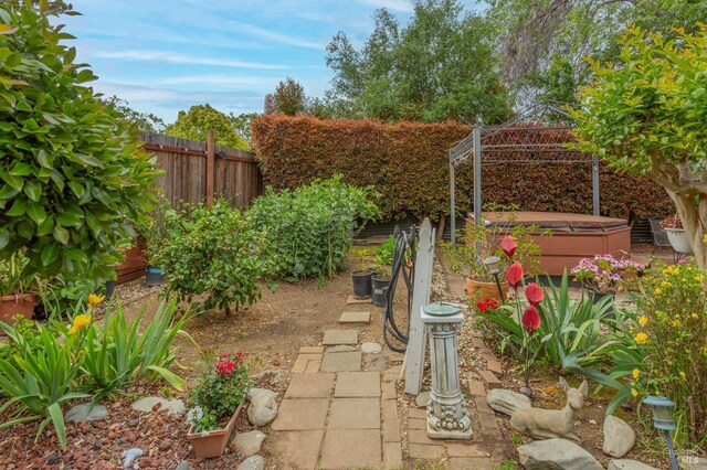 view of yard with a hot tub and fence