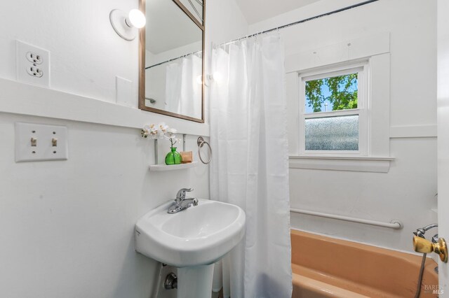 full bathroom with shower / bath combination with curtain and a sink