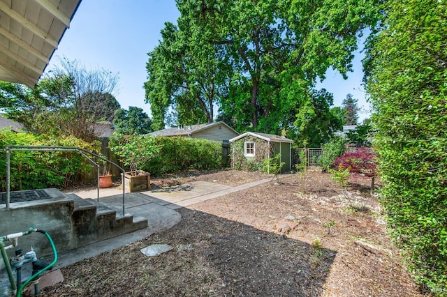view of yard with a patio area, an outbuilding, a storage shed, and a fenced backyard