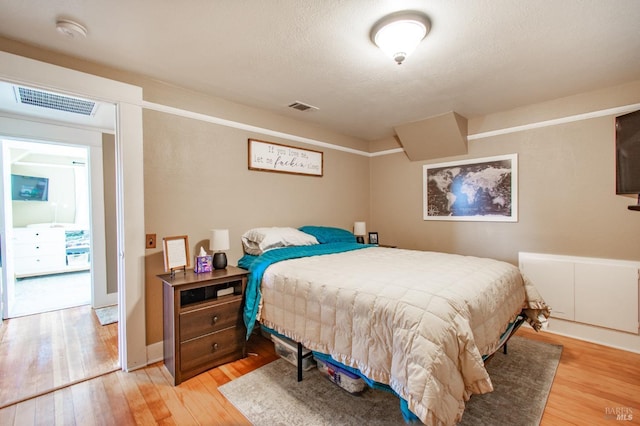 bedroom with light wood-style flooring and visible vents