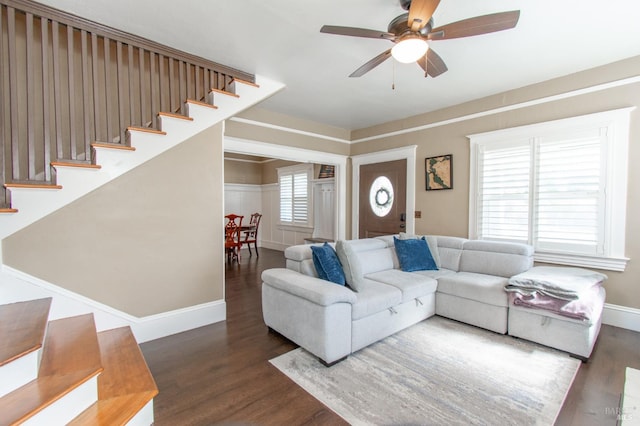 living area featuring stairway, wood finished floors, baseboards, and ceiling fan
