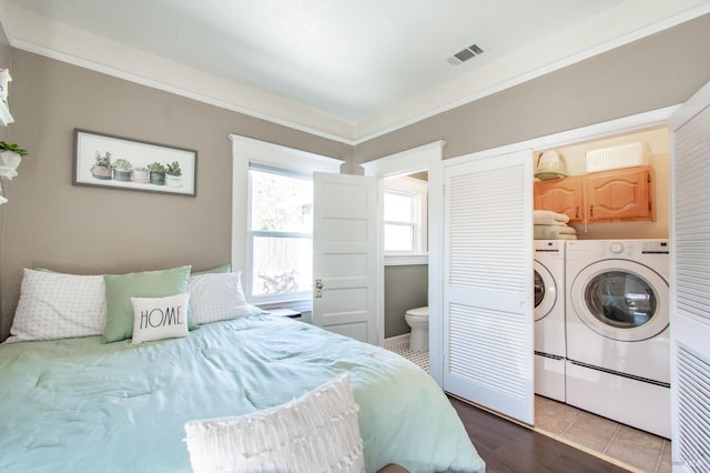 bedroom with crown molding, independent washer and dryer, visible vents, and connected bathroom