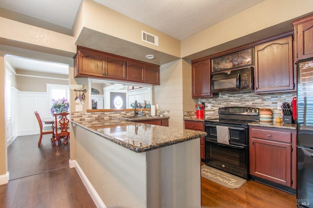 kitchen featuring visible vents, tasteful backsplash, black appliances, and dark wood-type flooring