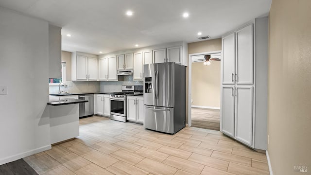 3087 Pecan Cir, Fairfield, CA 94533 - kitchen with stainless steel appliances, under cabinet range hood, ceiling fan, decorative backsplash, and dark countertops