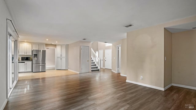 3087 Pecan Cir, Fairfield, CA 94533 - unfurnished living room with stairs, wood finished floors, visible vents, recessed lighting, and baseboards