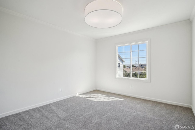 carpeted empty room featuring crown molding and baseboards