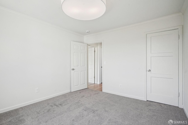 unfurnished bedroom with ornamental molding, carpet flooring, and baseboards