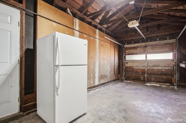 garage featuring freestanding refrigerator and a garage door opener