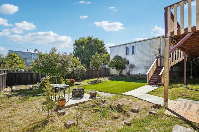 view of yard featuring a fire pit, stairway, a patio area, and a deck
