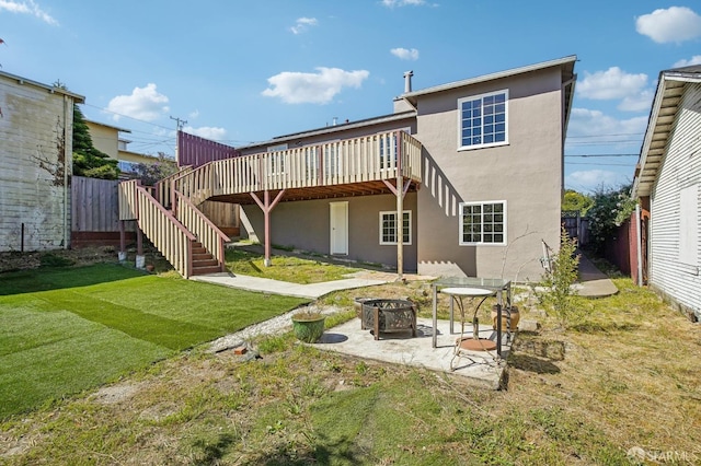 rear view of property featuring an outdoor fire pit, stucco siding, a deck, a patio, and stairs
