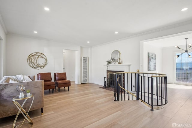living area with a heating unit, ornamental molding, light wood-style floors, recessed lighting, and a chandelier