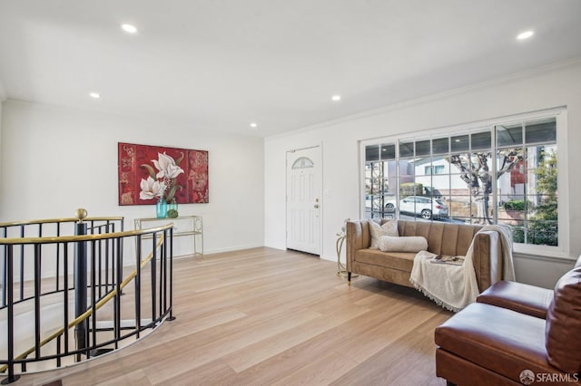 living area with crown molding, light wood-style flooring, recessed lighting, and baseboards