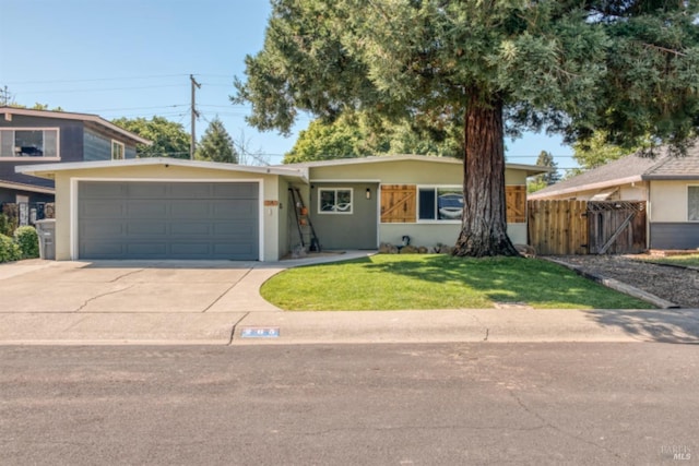 ranch-style home featuring fence, an attached garage, stucco siding, concrete driveway, and a front yard