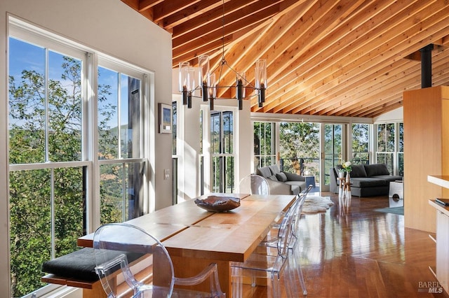 sunroom / solarium with lofted ceiling with beams, an inviting chandelier, and wood finished floors