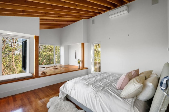 bedroom featuring a high ceiling, wood finished floors, and a wall unit AC