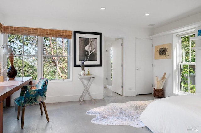 bedroom with baseboards, multiple windows, finished concrete flooring, and recessed lighting
