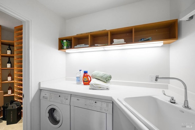 clothes washing area featuring laundry area, a sink, and washer and clothes dryer