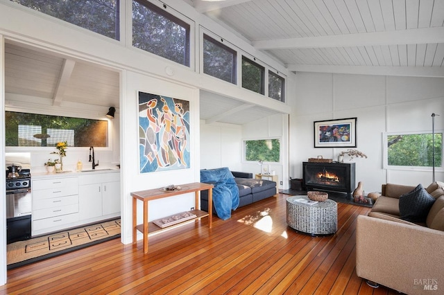living area with wood-type flooring, beamed ceiling, and plenty of natural light